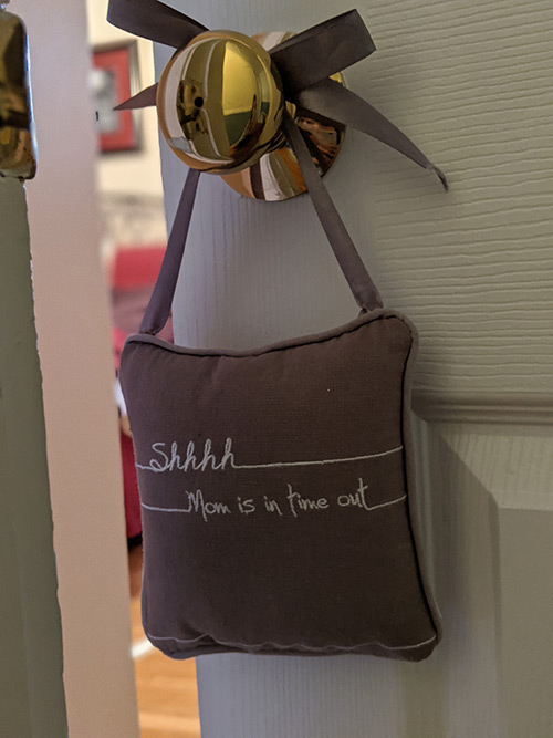 A door hanger that says, shhh Mommy is in Time Out