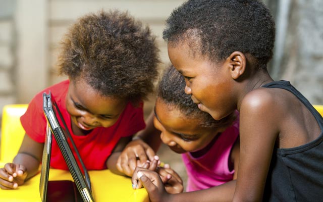 African-American children playing with tablet