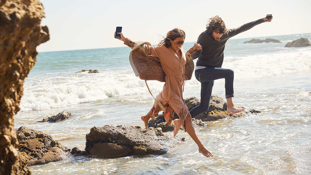 Couple jumping in ocean