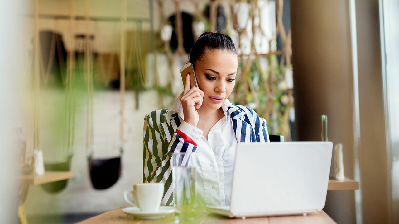 Woman in front of laptop and cell phone