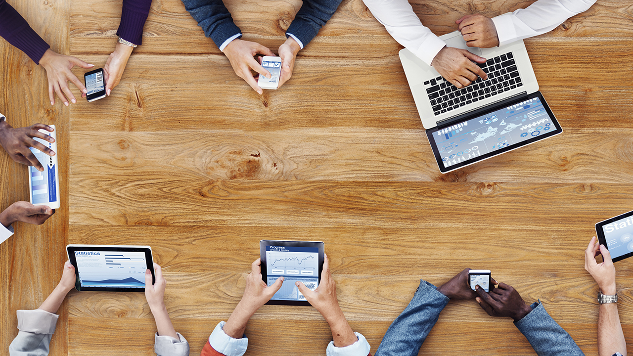 People with devices at table