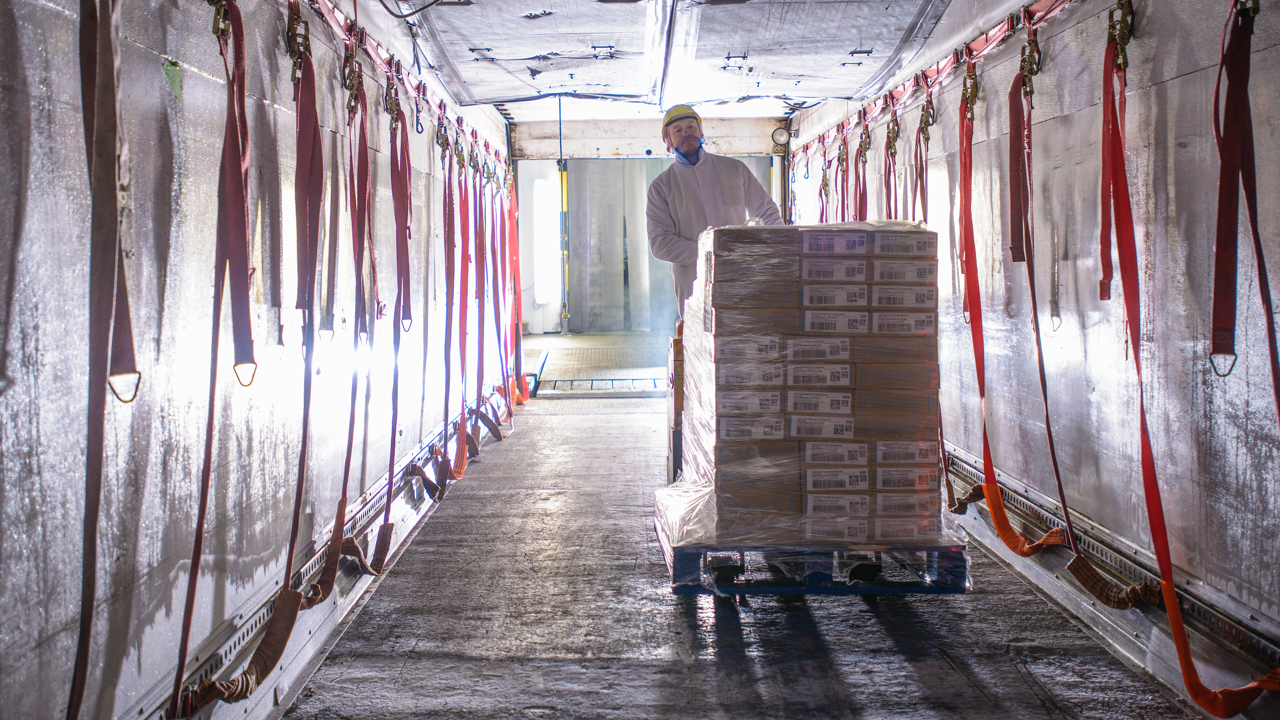 Man in warehouse pushing boxes