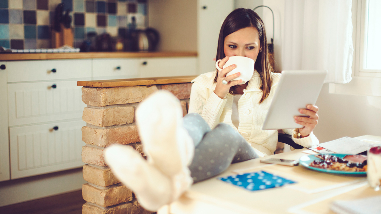 Woman sipping coffee on laptop