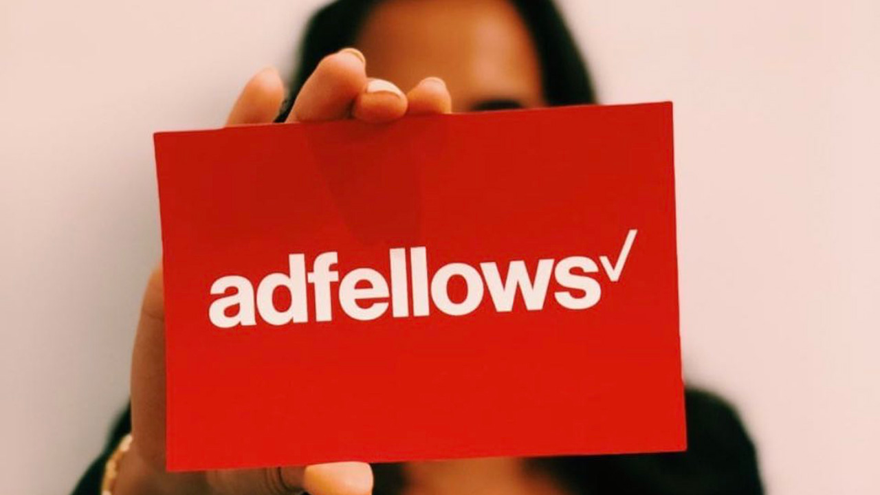 Adfellows graduation day - girl holding Adfellows sign