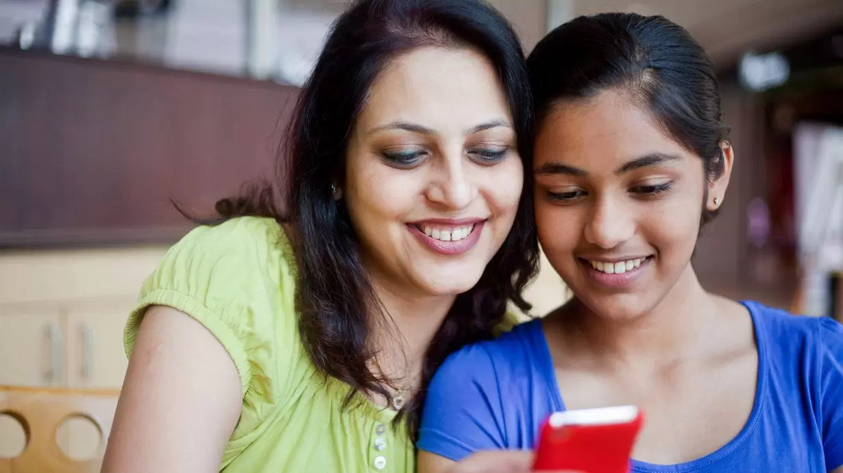 Daughter Sharing Family Photos With Her Mother
