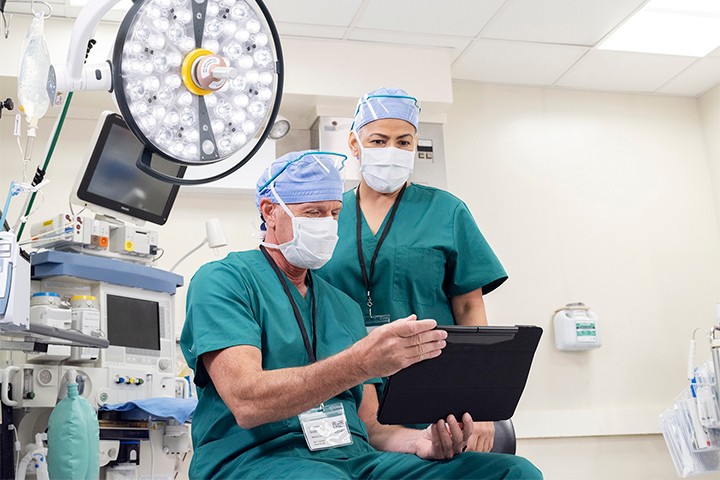 Two healthcare professionals reviewing data on tablet