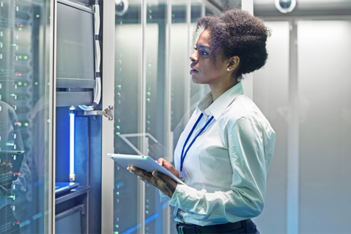 Female cyber security professional inspecting hardware within a server data room