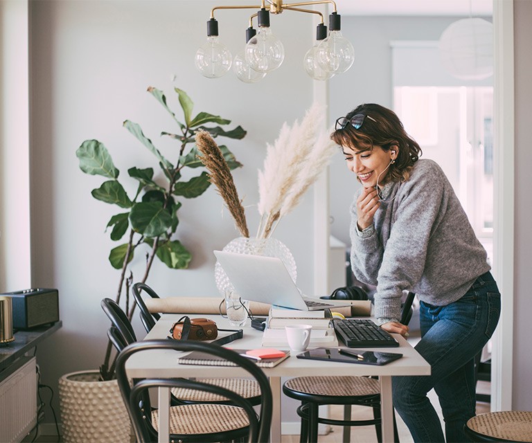 A woman talking on the phone while working from home.