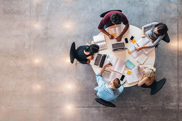 Bird's eye view of five students studying at a round table