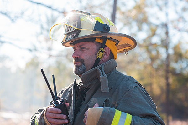 A firefighter holding a walkie-talkie
