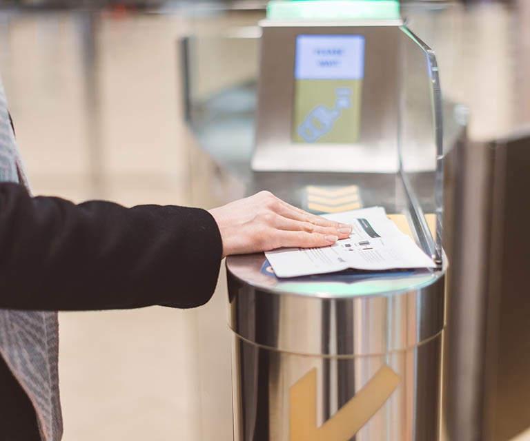 Electronic Boarding pass and passport control in the airport - hand with boarding pass at the turnstile.