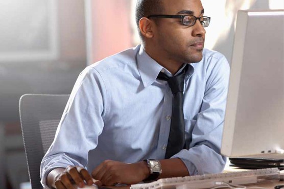 Man wearing glasses using a computer