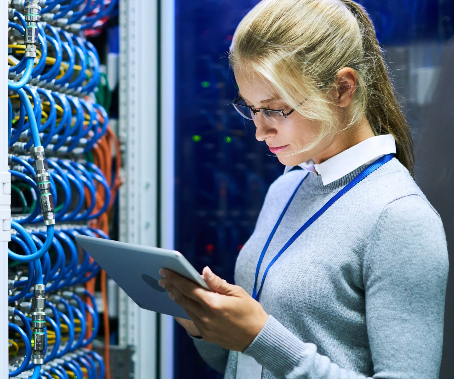 Woman wearing glasses using tablet by cables