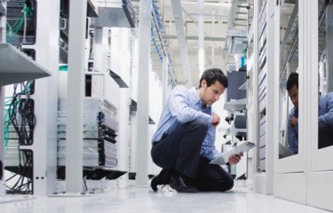 Man with a clipboard looking at servers