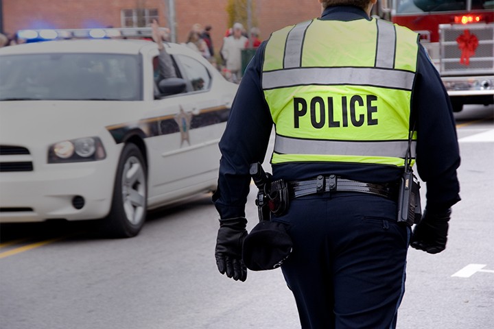 Police officer standing near a patrol vehicle and firetruck