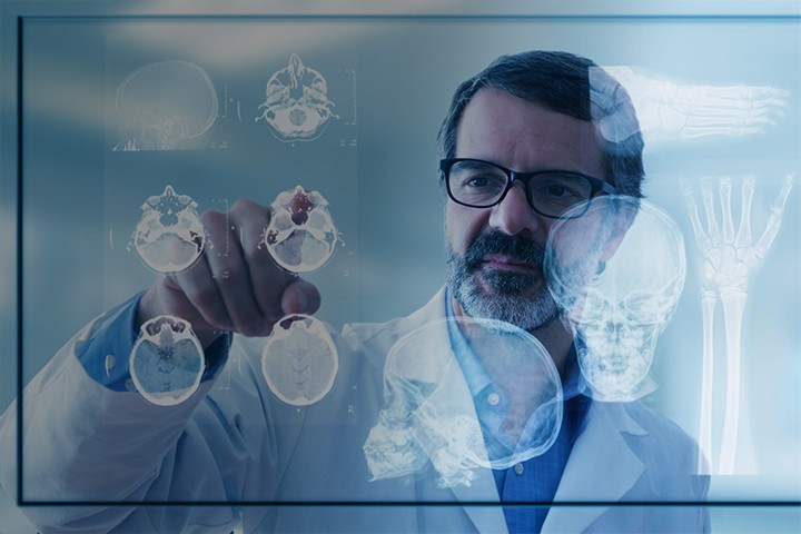 Doctor using futuristic technology by tapping on patient scans on a transparent monitor
