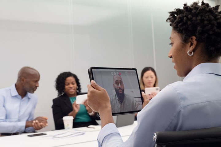 Employees in meeting looking at devices
