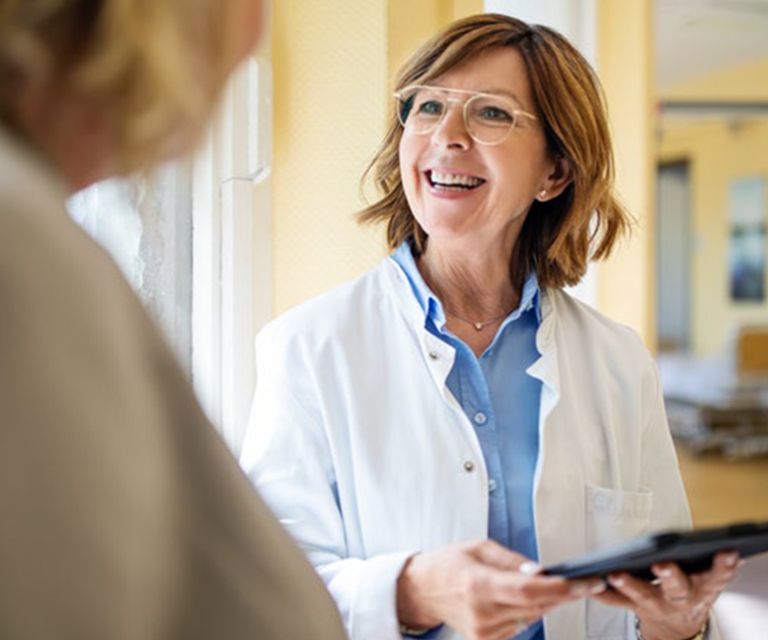 Doctor holding a tablet while talking with patient