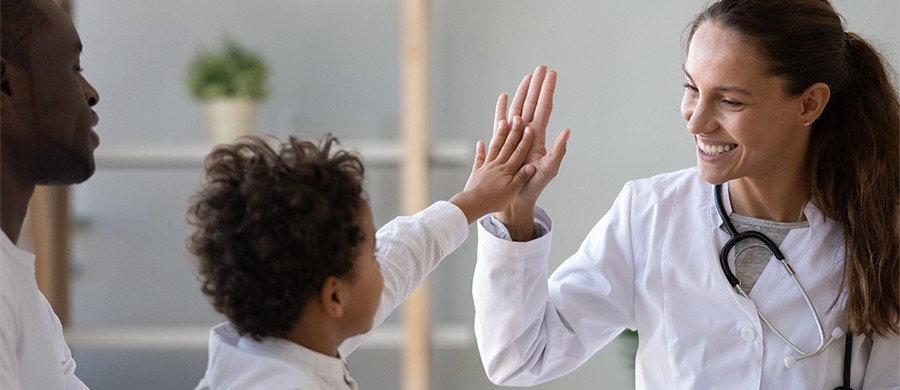 Smiling female doctor giving a high-five to young child