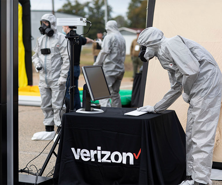 medical worker looking at computer laptop on Verizon table