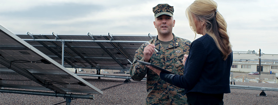 Major Steven Harvey talking with a woman holding tablet