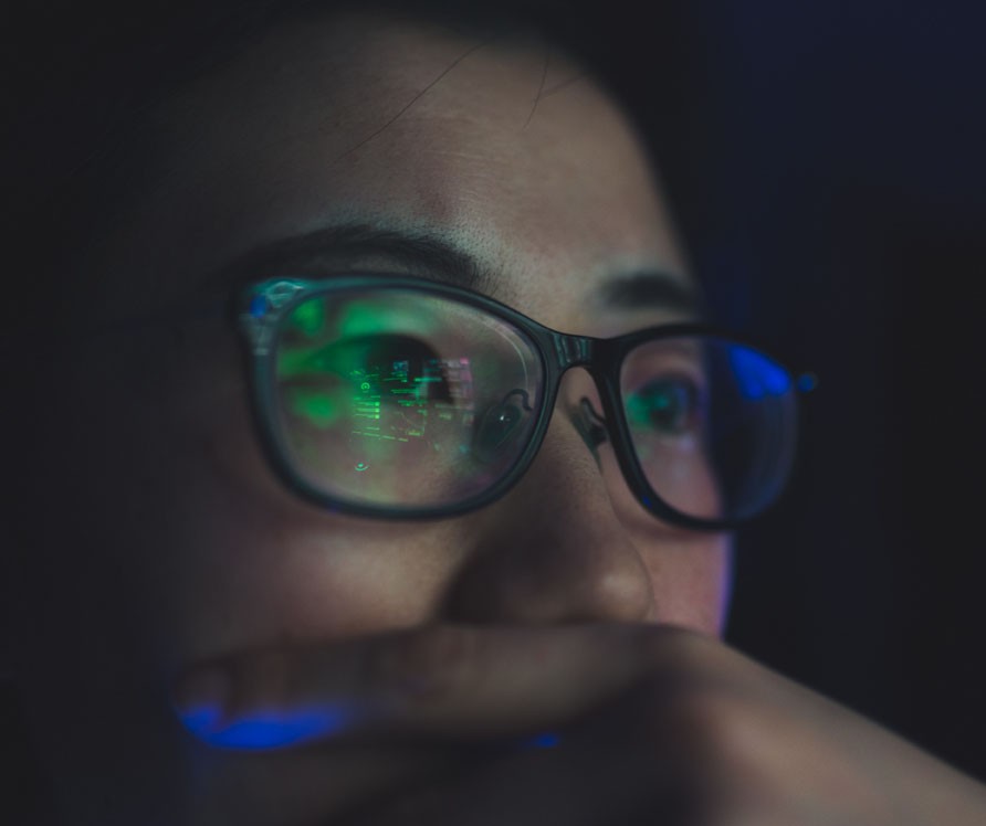 woman with glasses face up in a dark room