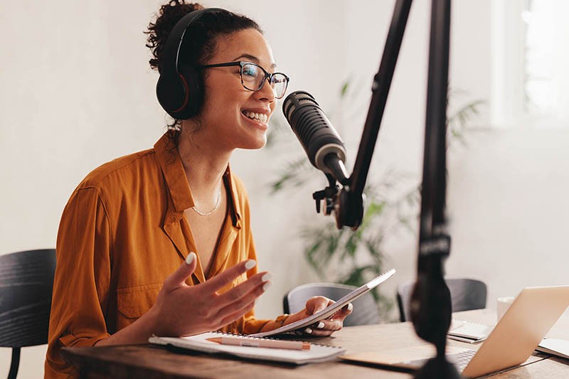 Female podcaster making audio podcast from her home studio