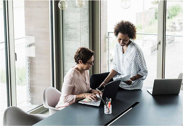 two women looking at the laptop at the meeting desk