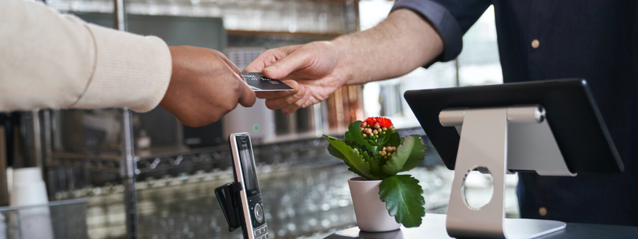 A customer hands a cashier their payment card.