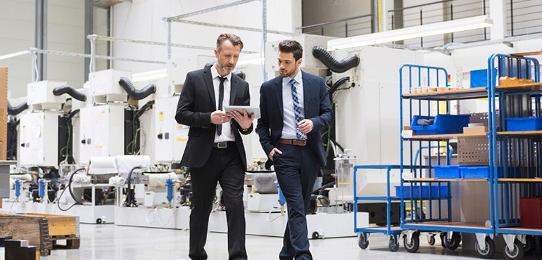 Two men walking in warehouse.