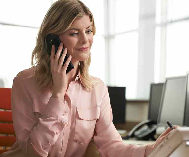 Woman holding phone in office setting