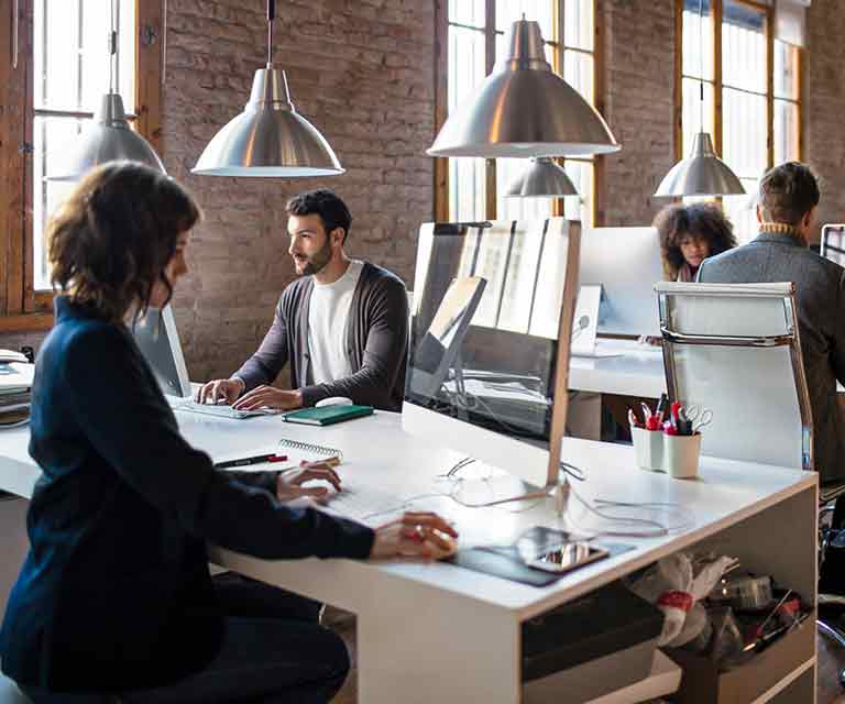 A group of employees work at high-top tables in an office