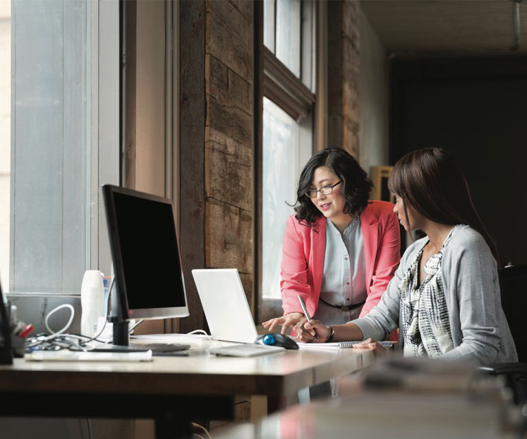 Two women looking at a laptop