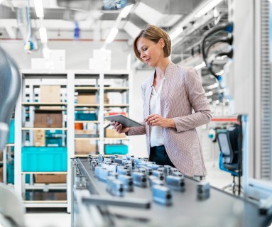woman holding a mobile devise tracking manufactured product