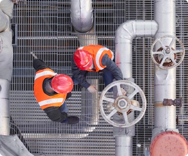 utility workers wearing hard hats and construction vests working on oil, gas and mining lines