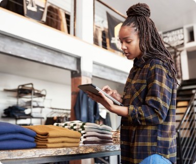 retail worker taking inventory of store merchandise with a handheld mobile device