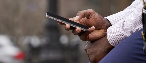 A close-up view of a man holding a smartphone.