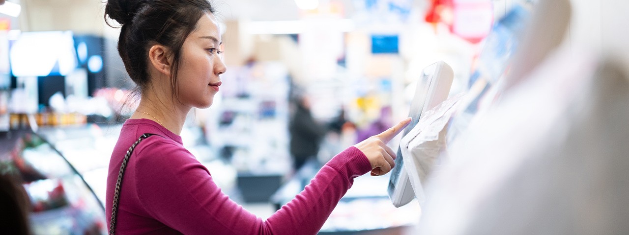 woman shopper at self=serve checkout