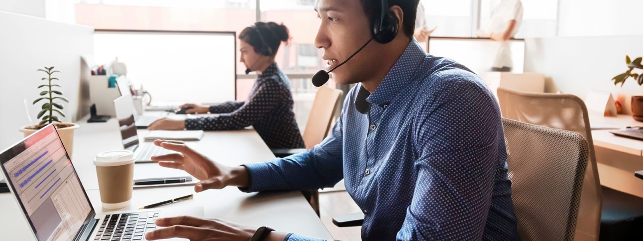 employees with headphones and laptops