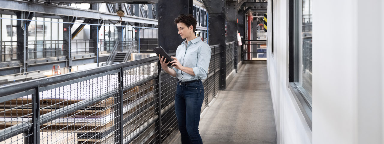 employee with tablet in manufacturing plant