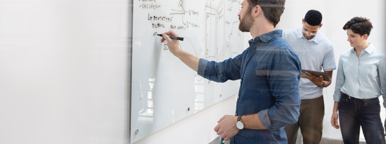 co-workers writing on a whiteboard
