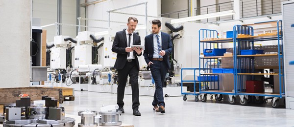 Two men in suits walking through a warehouse