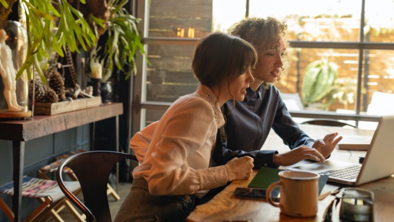 women looking at laptop on table