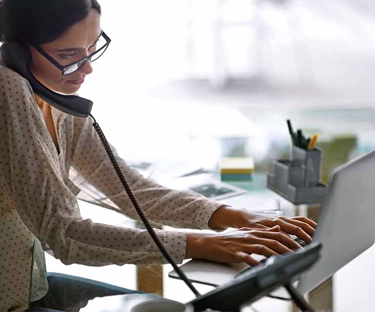 Woman on phone and laptop