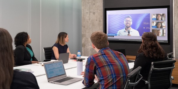 In-office workers interacting with video conference screen