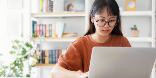 Woman sitting a table looking at her laptop