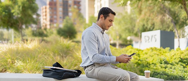 Man sitting outside looking at his smartphone.