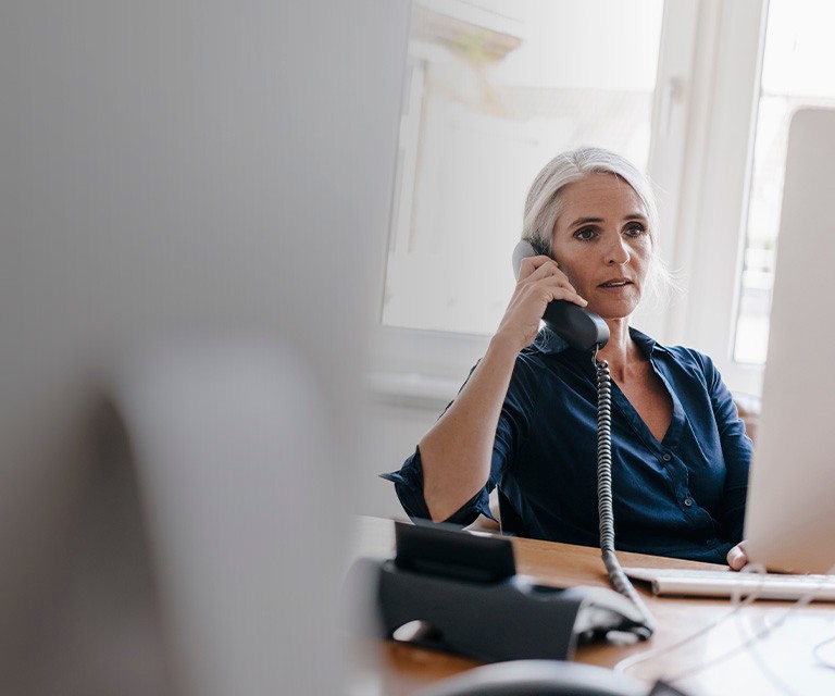 Woman talking on desk phone