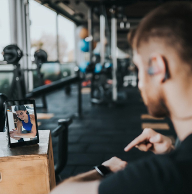 Personal health training video conferencing with client while at gym