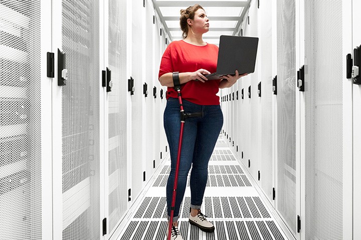 Women using laptop in server room.
